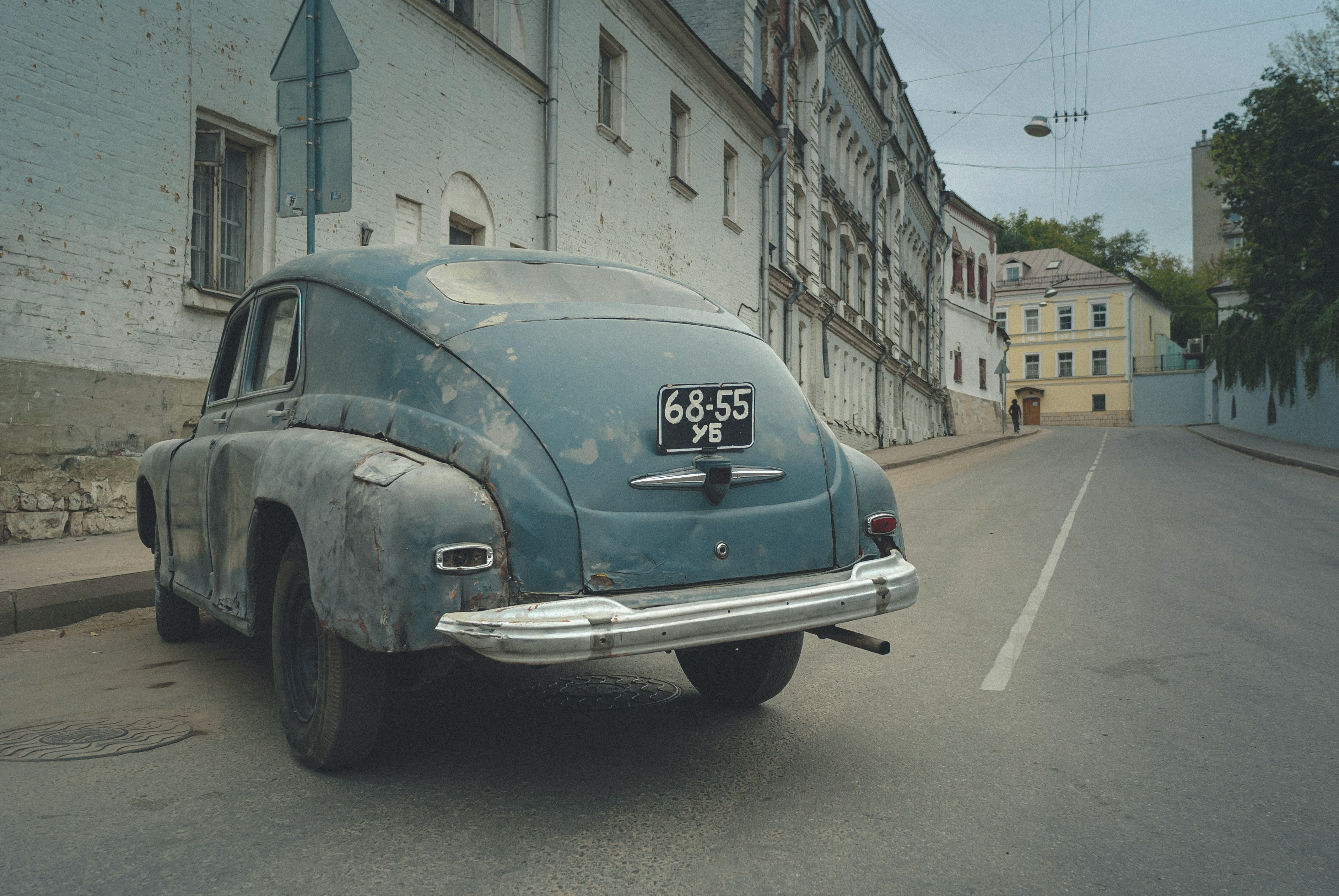 blue classic car parked beside building during daytime